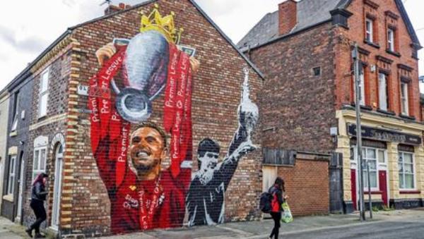 A new mural of Liverpool captain Jordan Henderson lifting the Premier League trophy and former captain Alan Hansen lifting the league trophy by artist Paul Curtis on the gable end of a house on Old Barn Road in Anfield, Liverpool. Photo credit: Peter Byrne/PA Wire